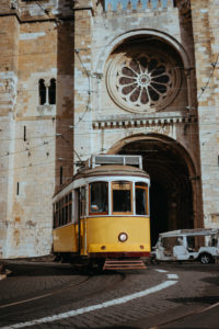 Quaint yellow tram passes directly in front of the Se Cathedral in Lisbon, Lisboa, Lissabon, Portugal, Europe Quaint yellow tram passes directly in front of the Se Cathedral in Lisbon, Lisboa, Lissabon, Portugal, Europe
